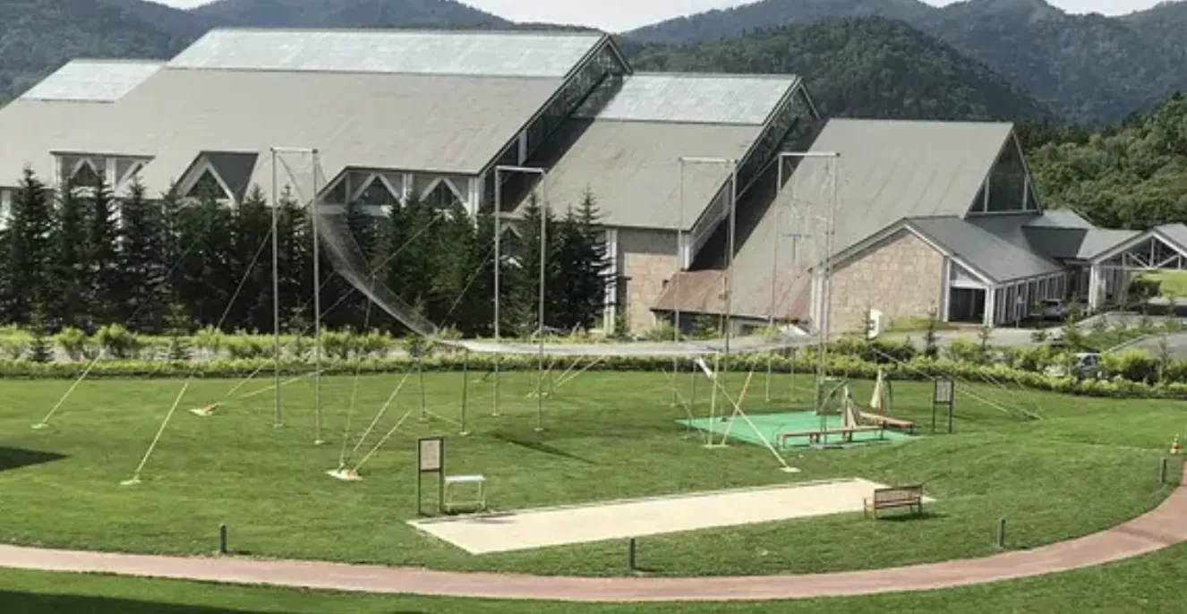 Full-size flying trapeze rig on the lawn at a Hokkaido mountain resort — Club Med Tomamu, Japan — MACA flying trapeze rig