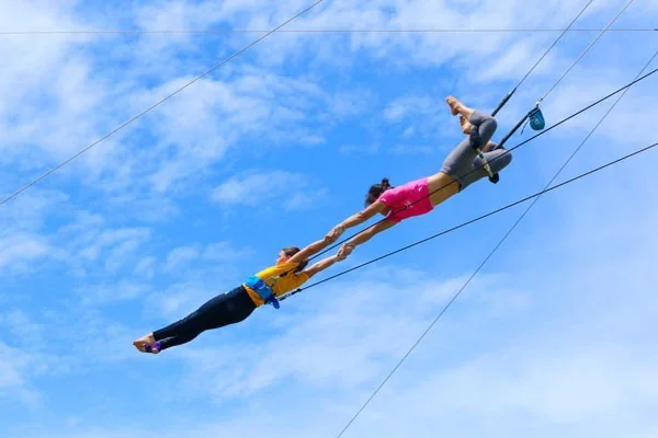 Catcher and flyer in a mid-air catch — MACA flying trapeze operations — MACA flying trapeze rig